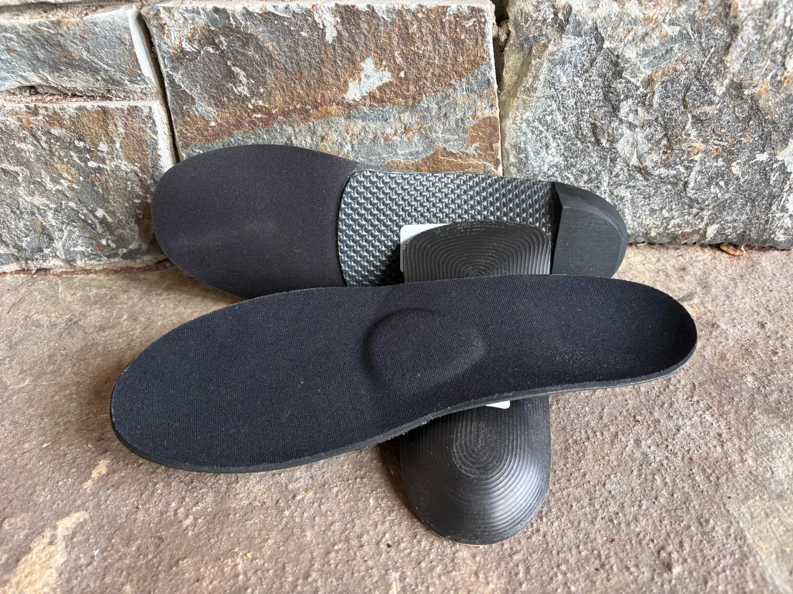 Finished samples of custom orthotics on a stone step
