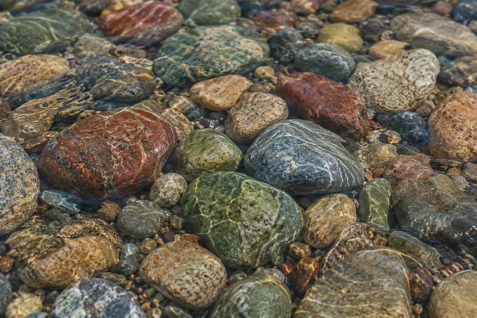 Smooth colored stones under clear water
